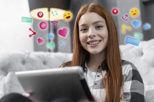 Tributação para social media - imagem de gestora de redes sociais com notebook sorrindo